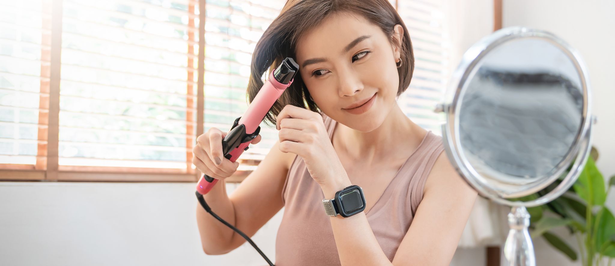 Woman using a hair curler to style her hair